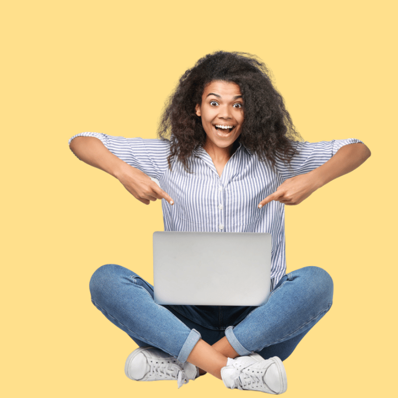 Frau auf gelbem Hintergrund zeigt auf Laptop und guckt euphorisch