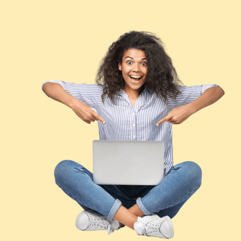 Frau auf hellgelbem Hintergrund zeigt auf Laptop und guckt euphorisch