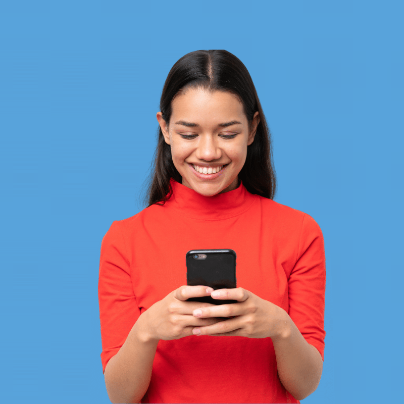 Frau auf blauem Hintergrund lächelt und schaut auf Smartphone