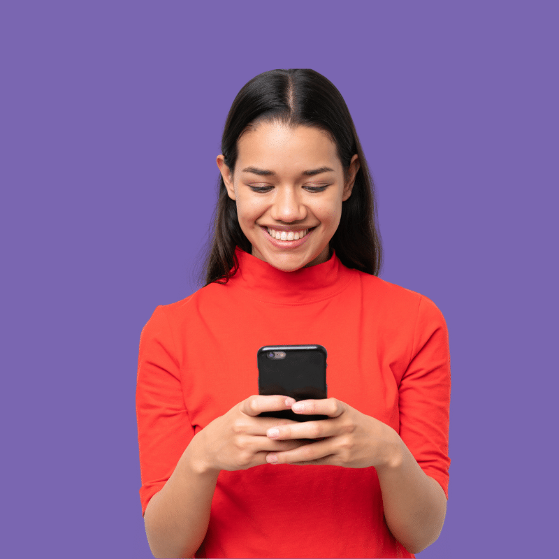 Frau auf lila Hintergrund lächelt und schaut auf Smartphone